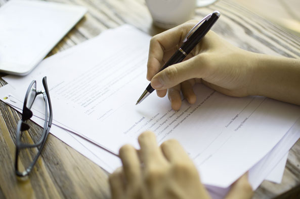 Businessman-examining-papers-at-table